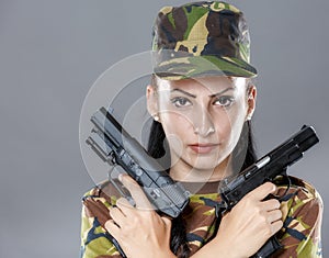 Female soldier in camouflage uniform with weapon