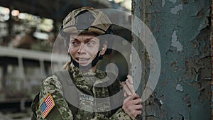 Female soldier crying during operation in destroyed building