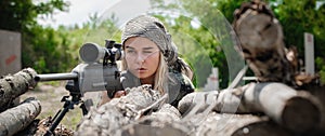 Female soldier shooting with sniper rifle. Woman with weapon