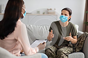 Female Soldier Wearing Uniform And Mask Talking To Psychiatrist At Therapy Session