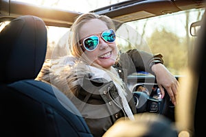 Female solo traveler, independent spirit, with raised arms to the sky, enjoying the freedom of the outdoors and nature in vehicle