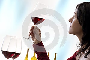 Female sommelier evaluating red wine against clear background