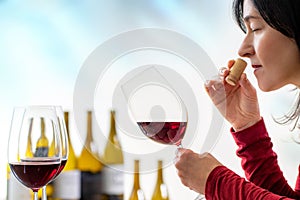 Female sommelier smelling wine cork at tasting.