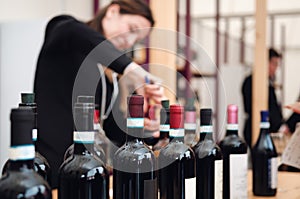 Female sommelier uncorking a bottle of red dolcetto wine in piedmont, italy