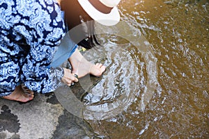 Female spa feet cleaning with stone on the nature river stream - woman having her feet scrubbed , Spa foot massage