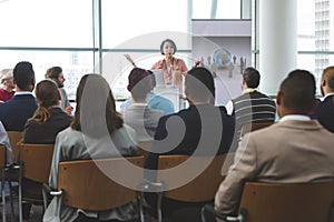 Female speaker with laptop speaks in a business seminar