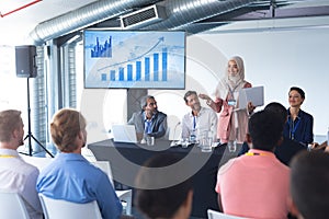 Female speaker with laptop speaks in business seminar