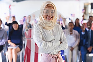 Female speaker standing with arms crossed in business seminar at conference meeting