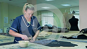 Female specialist is nailing pieces of fabric with a hammer