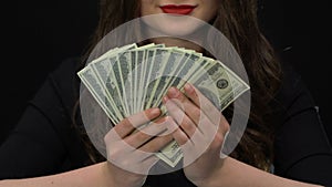 Female speculator showing dollars earned on frauds with bank accounts, money