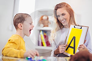 Speech therapist teaches the boys to say the letter A