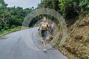 Female sport model running on road in mountains. Fitness woman training outdoors.