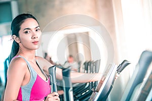 Female in sport wear is working out on Step climber machine in fitness gym for healthy lifestyle concept portrait