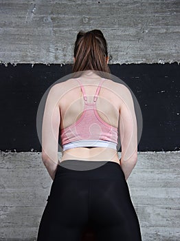 Female a sports back viewed from behind. Body. Fit . Work in gym.