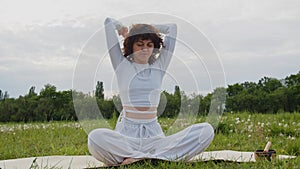 Female sports woman practicing pranayama exercise outdoors. Female throwing air behind her back. Young girl using