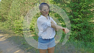 Female spraying insect repellents on skin in forest