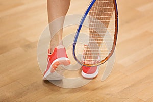 Female squash player hiting a ball in a squash court