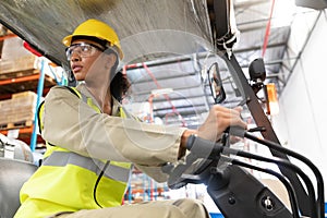 Female staff driving forklift in warehouse