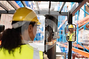 Female staff driving forklift in warehouse