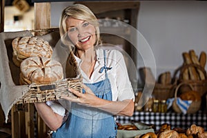 Female staff holding basket of sweet foods in bakery section