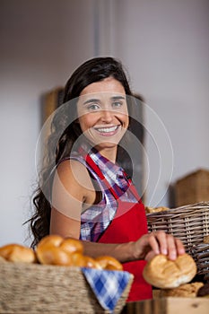 Female staff holding basket of sweet foods in bakery section