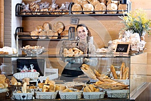 Female staff selling fresh pastry and baguettes