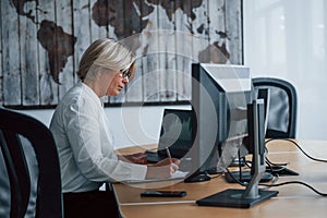 Female stockbroker in formal clothes works in the office with financial market