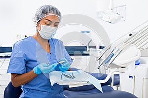 Female stomatologist preparing dental instruments for work