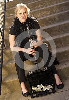 Female Street Performer Sits on Steps Clarinet Case With Tips