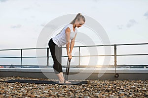 Female with stretch band working out on mat outdoors
