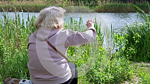 Female Stretches Hand to the Sun, Waving Hi Sitting in Nature, Looking on River