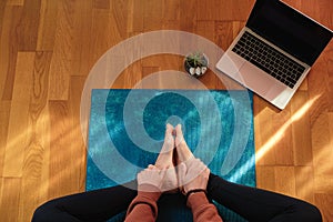 Female stretching over a mat during online yoga class