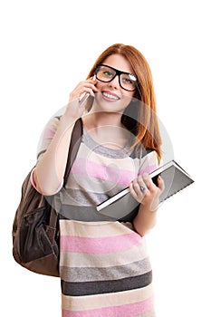 Female student with backpack and notebook talking on mobile phone