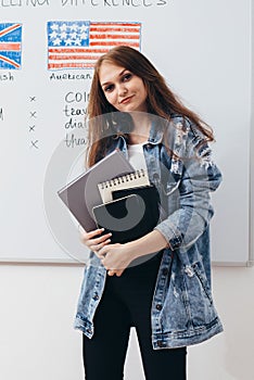 Female student with books in classroom English language school.
