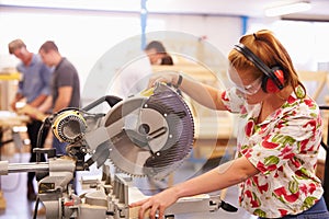 Female Student In Carpentry Class Using Circular Saw