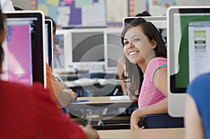 Female Student With Classmates In Computer Laboratory