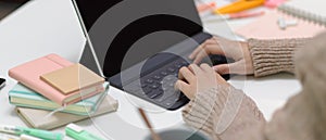 Female student doing assignment with digital tablet on study table