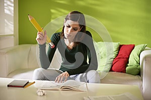 Female student doing homeworks with big pencil