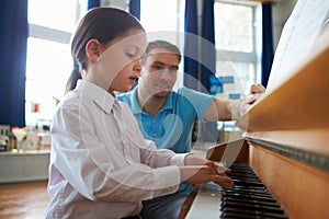 Female Student Enjoying Piano Lesson With Teacher