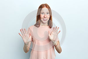 Female student with freckles showing rejection sign, saying no.
