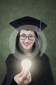Female student giving bright light bulb