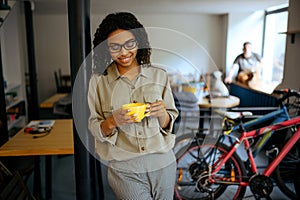 Female student in glasses drinks coffee in cafe