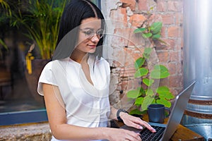 . Female student in glasses online learning via notebook gadget