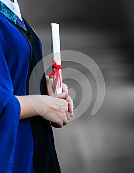 female student in gown holding a diploma