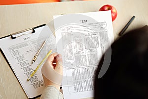 Female student hands testing in exercise and hold exam paper sheet with pencil at school test room