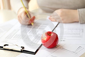 Female student hands testing in exercise and taking fill in exam paper sheet with pencil at school test