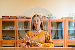 Female student holding molecular structure model. Science class concept.
