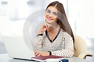 Female student with laptop in a high school library