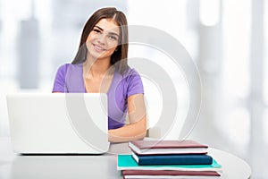 Female student with laptop in a high school library