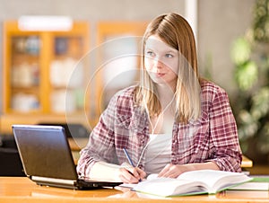 Female student with laptop working in library